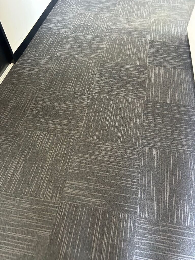 Close-up of patterned commercial carpet tiles in an office setting.