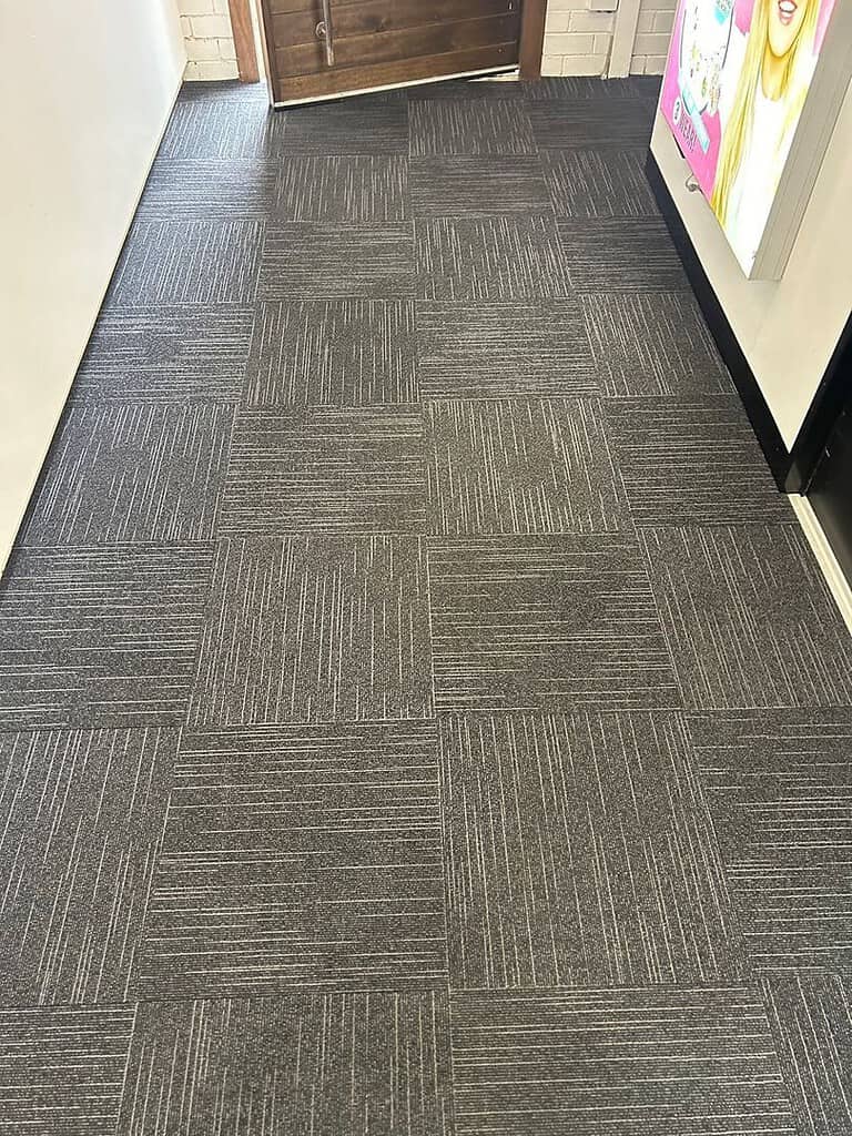 Commercial Hallway with Clean Carpet Tiles Image of clean dark gray carpet tiles in an office hallway.