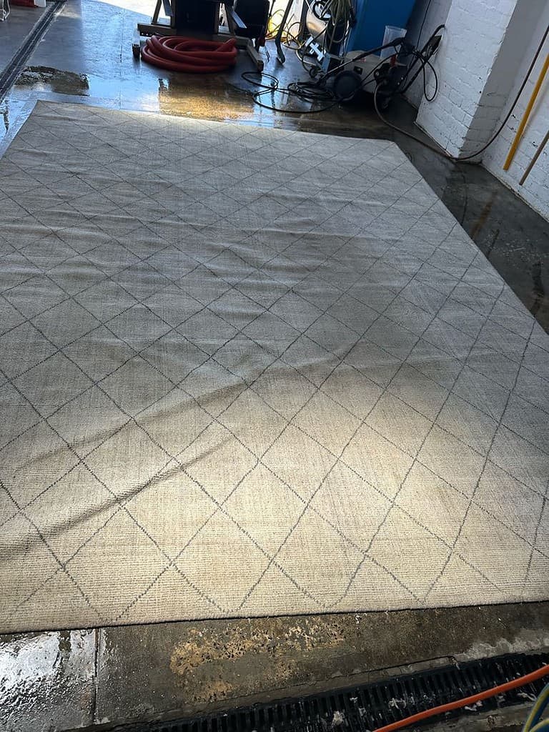 Rug with diamond pattern on wet floor in industrial environment.