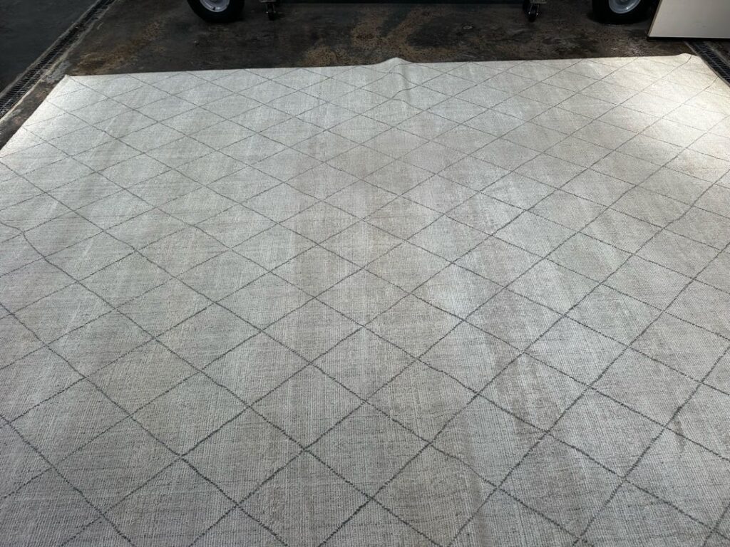 Diamond Pattern Rug in Industrial Setting Image of a large diamond-patterned rug on a concrete floor in an industrial space.