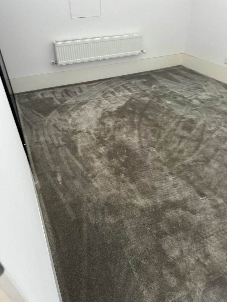 Image of a freshly cleaned plush carpet in an empty room with a white radiator.