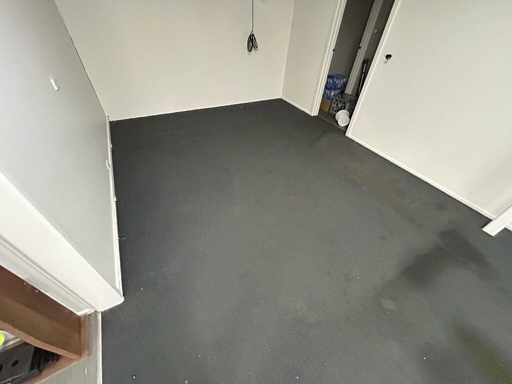 Image of a stained and soiled office carpet in a factory setting.