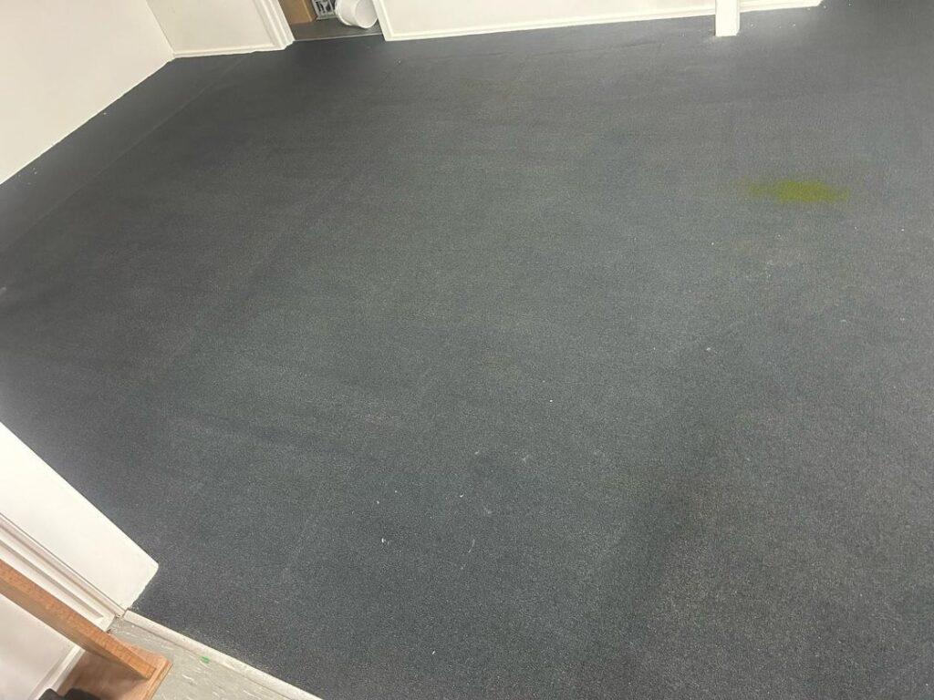 Office Carpet Cleaning Result in Dingley Village Image of a clean office carpet with a stain in an industrial setting.